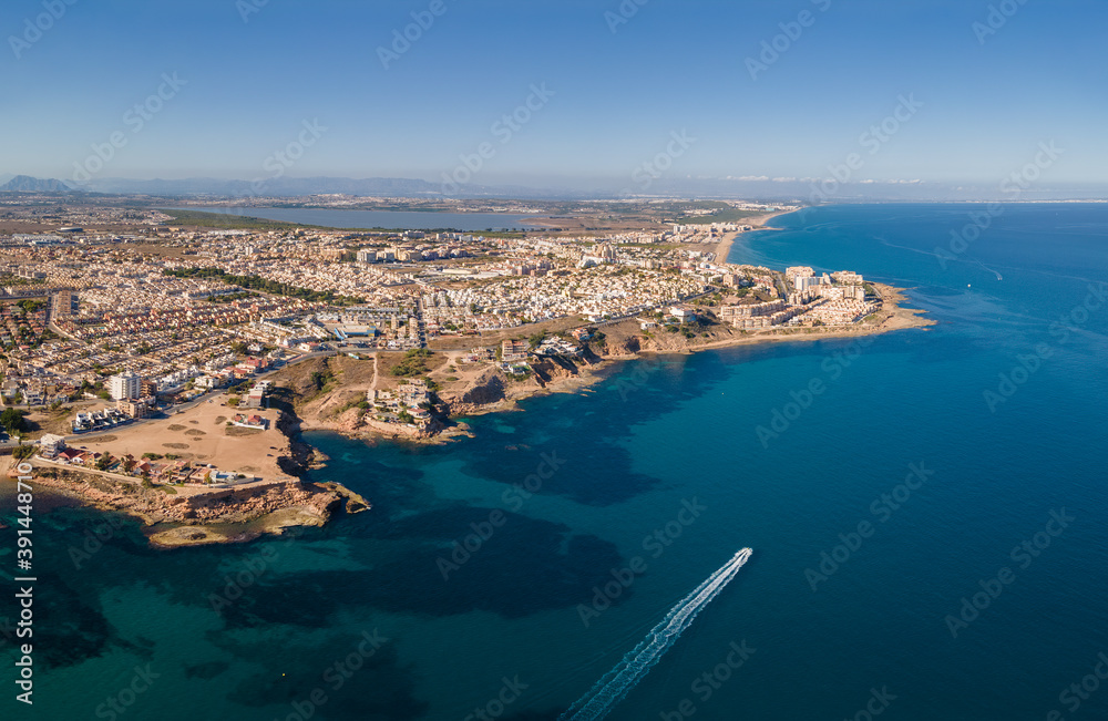 Aerial view of the northern part of the port city of Torreviejas on a sunny autumn afternoon. You can see the coastline and in the background the salt lagoon of La Mata.
