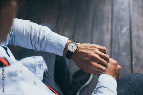 man fashionable wearing stylish looking at luxury watch on hand check the time at workplace.concept for managing time organization working,punctuality,appointment photo