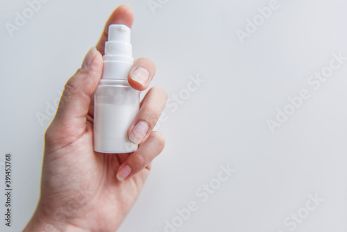 holding in hand the tube with some white liquid in it