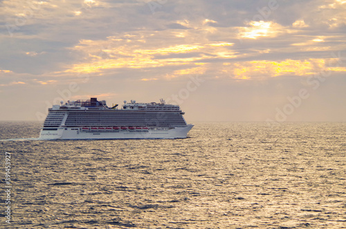 Dream vacation on modern Norwegian cruiseship or cruise ship liner Escape at sea during sunrise sunset twilight cruising with dramatic clouds in blue hour sky