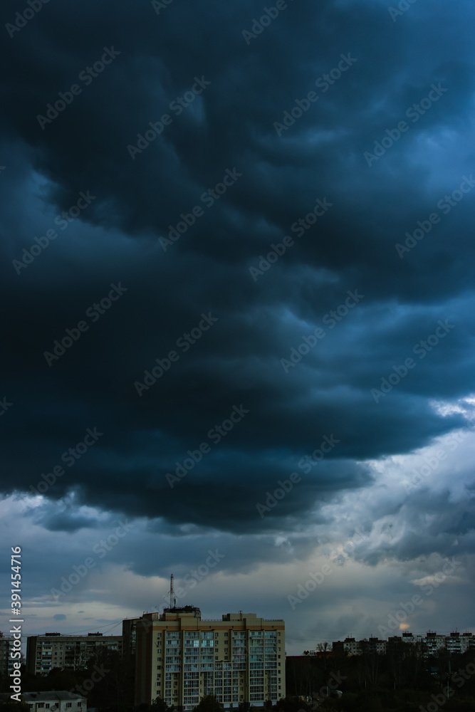 Dramatic dark cloudy sky over the horizon, natural blue background.