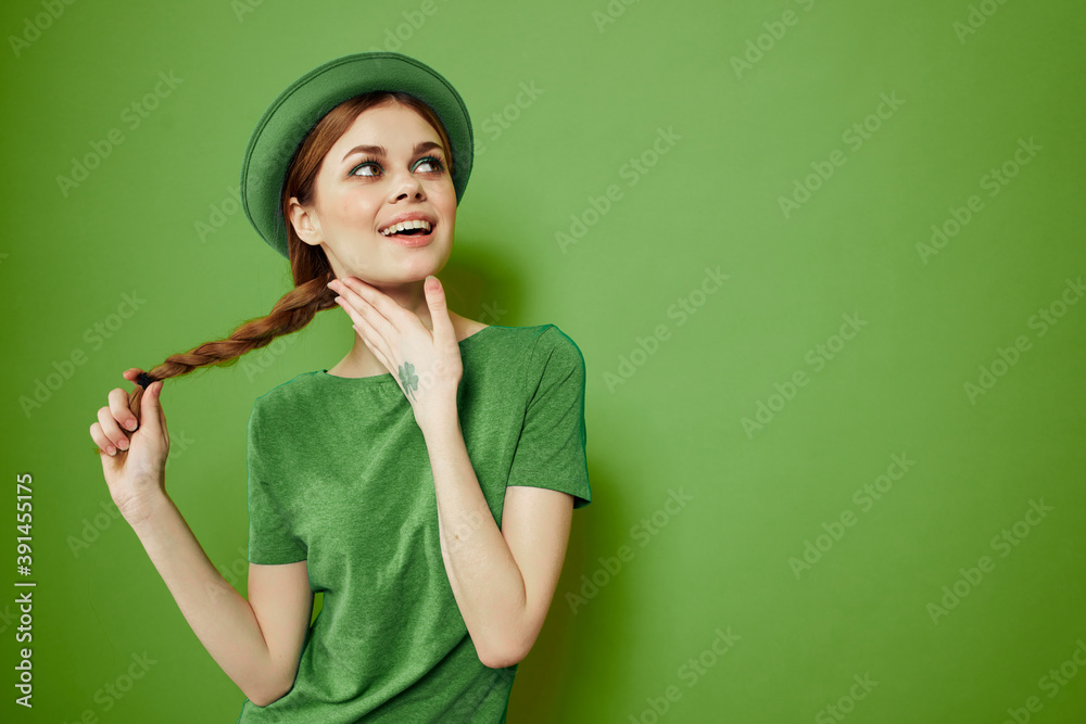 Happy woman with shamrock on St. Patrick's Day in green clothes and a hat on her head gesturing with her hands Happy woman with shamrock on St. Patrick's Day in green clothes and a hat on her head gesturing with her hands