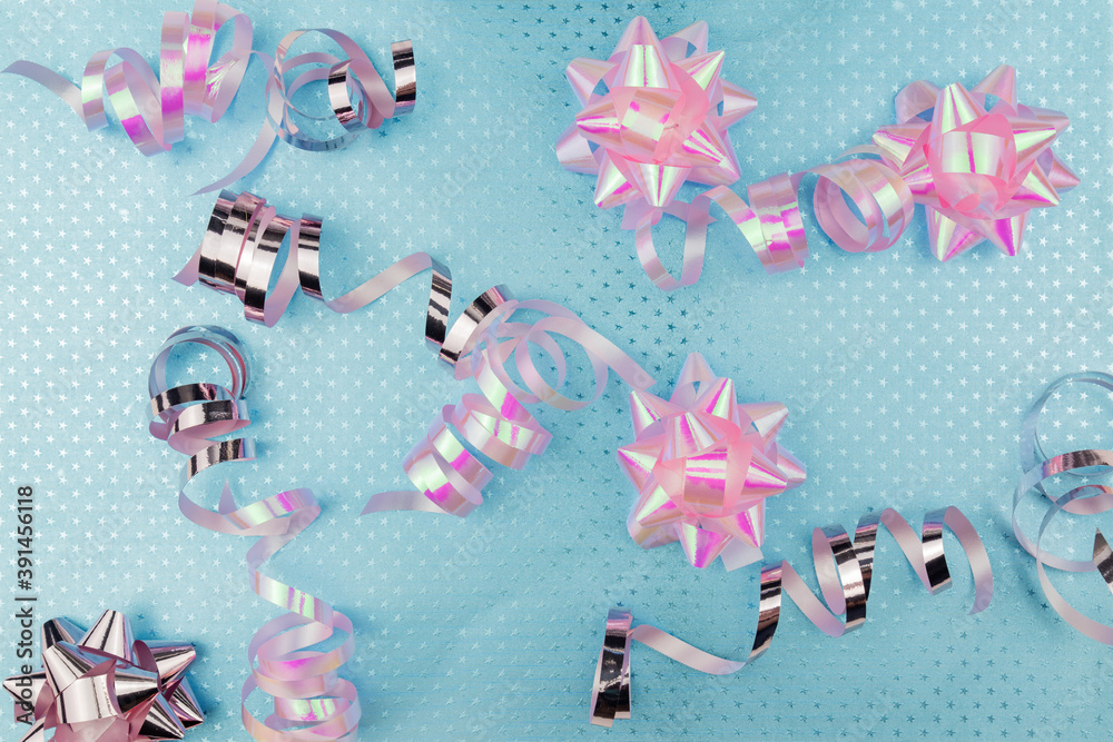 Christmas Holidays Background in pink and blue colors. Winter holidays, New Year. Flat lay, top view, copy space. Pink Streamers With Sparkling Glitter.