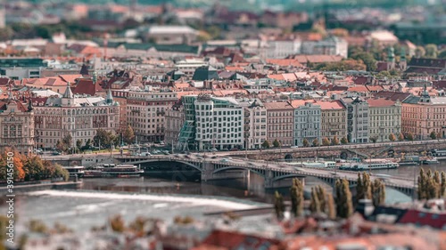 An autumn day. Busy traffic in Prague. Trams, cars, and busses pass on the cross-road in front of the famous Dancing House. Vltava river is a dirty grey-green. photo