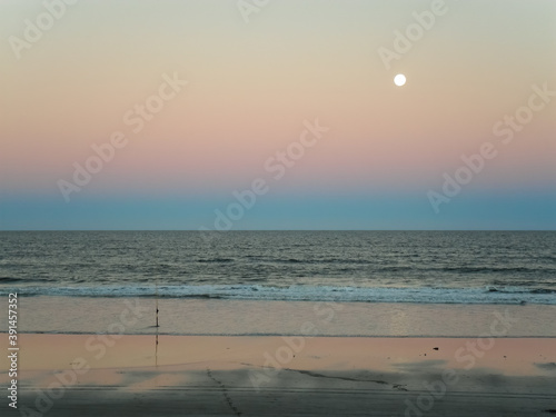 Full moon over the sea at sunset in the beach photo