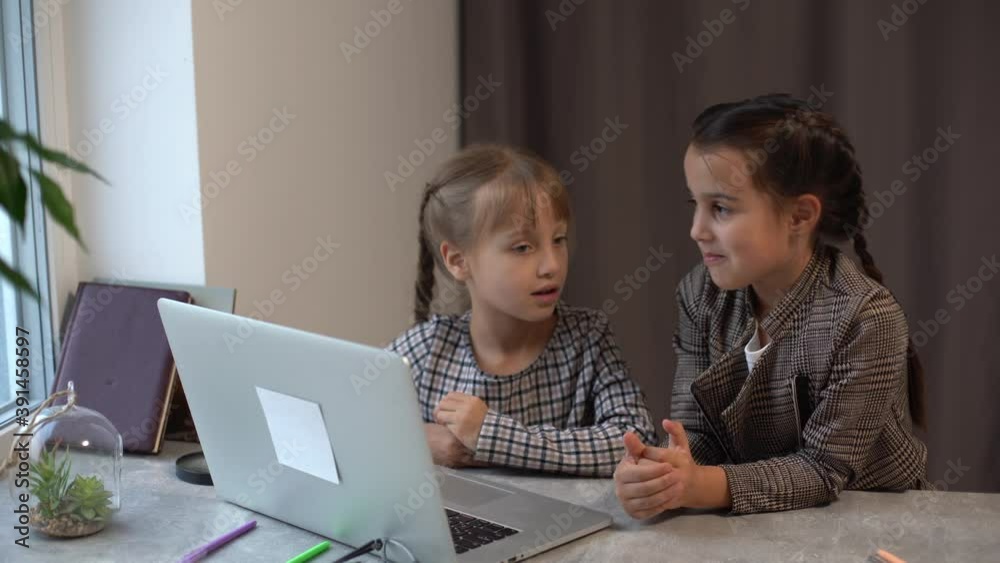Distance Learning. School Girls At Laptop Wearing Mask Studying Online Sitting at the table at home Distance Learning. School Girls At Laptop Wearing Mask Studying Online Sitting at the table at home