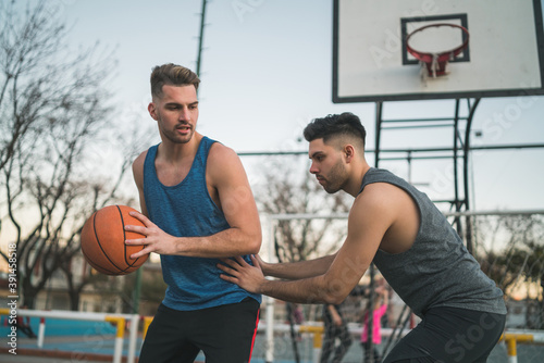 Two young friends playing basketball.