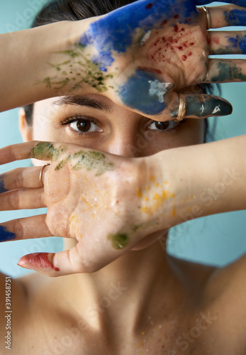 crazy portrait of young girl painter. photo of woman with paint brush strokes on the skin