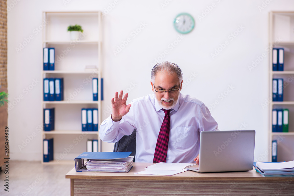 Old male employee working in the office Old male employee working in the office