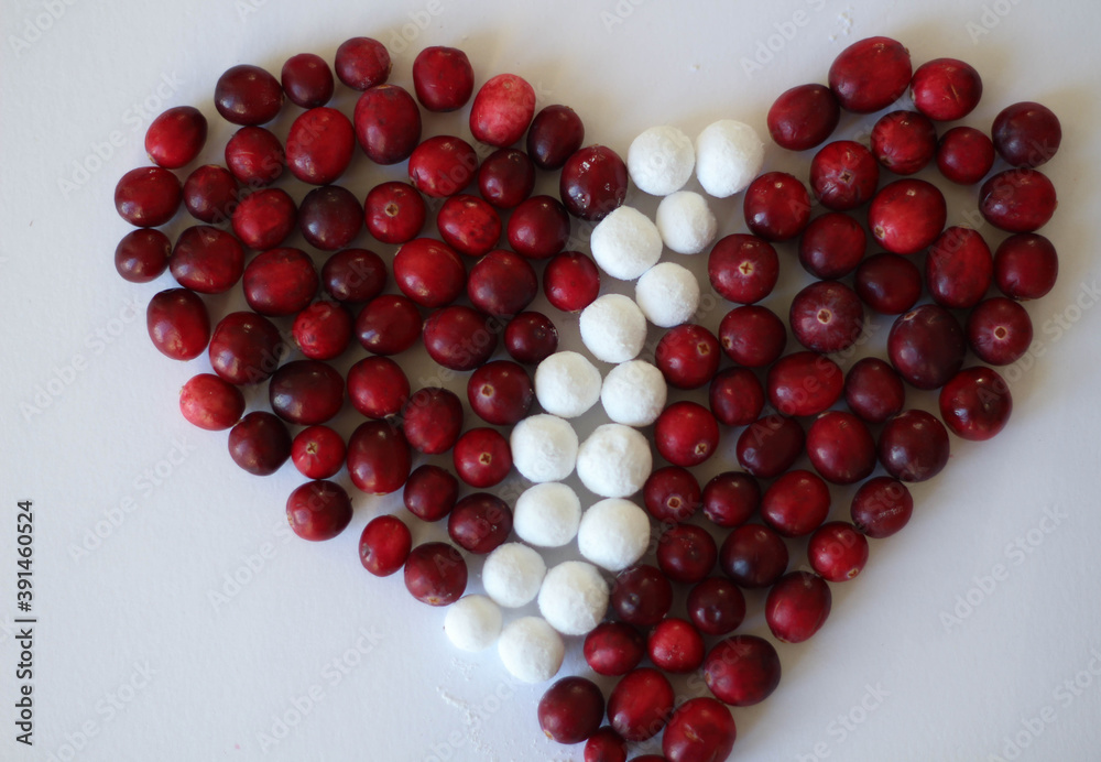 Wild cranberries, top view, paths. Cranberry in a heart shape on white background. Decoration. White and red. Latvia. Flag Wild cranberries, top view, paths. Cranberry in a heart shape on white background. Decoration. White and red. Latvia. Flag