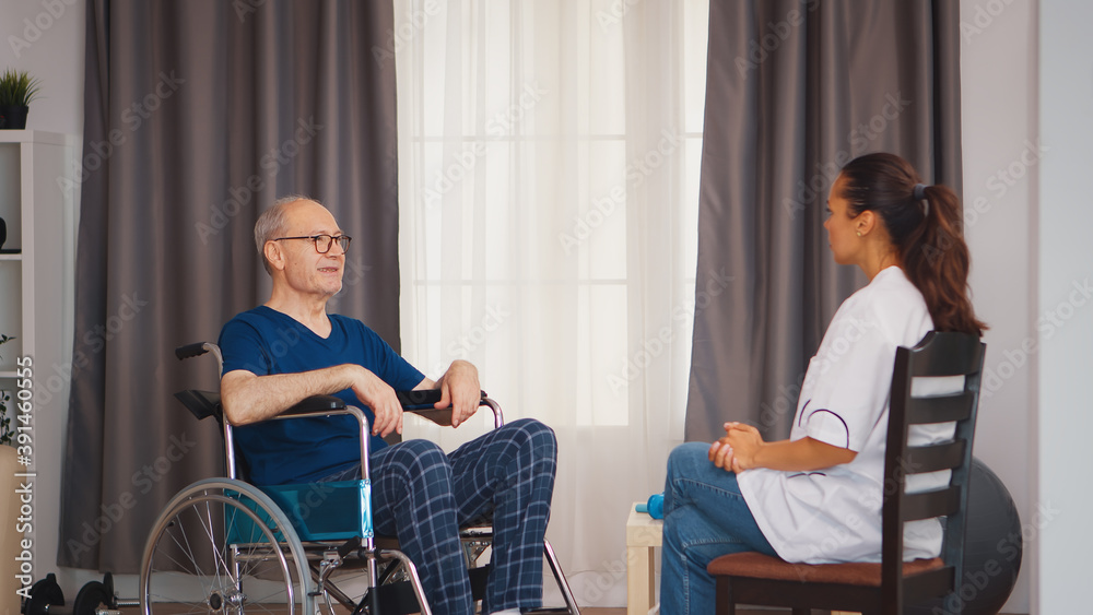 Old man in wheelchair talking with doctor. Disabled disability old person with medical worker in nursing care home assistance, healthcare and medicine service Old man in wheelchair talking with doctor. Disabled disability old person with medical worker in nursing care home assistance, healthcare and medicine service