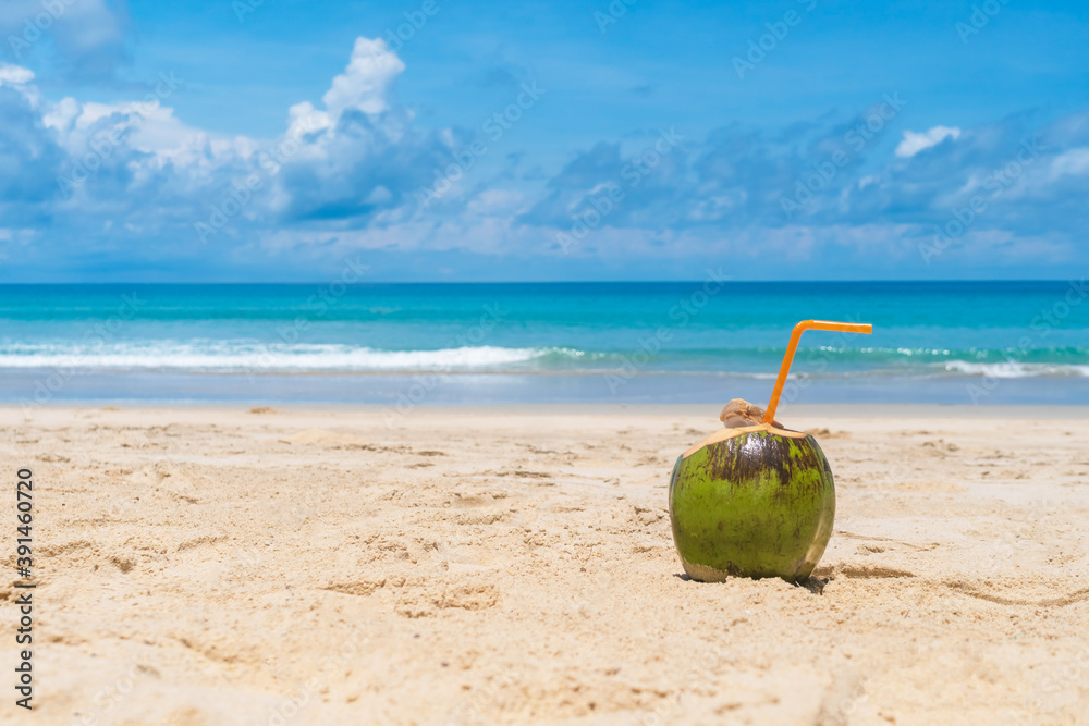 Fresh coconut on sand at summer beach blue sky.