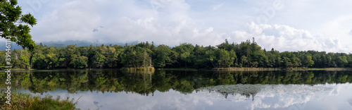 Panoramic view of forest reflecting in one of Shiretoko Five Lakes