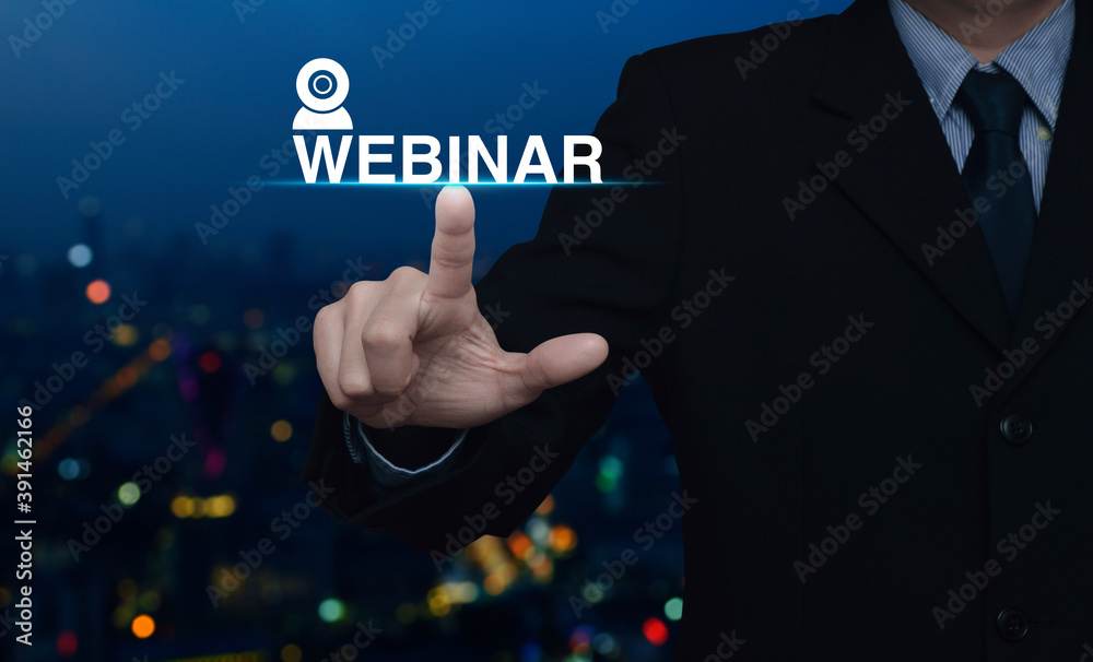 Businessman pressing webinar button over blur colorful night light modern city tower and skyscraper, Business seminar online concept Businessman pressing webinar button over blur colorful night light modern city tower and skyscraper, Business seminar online concept