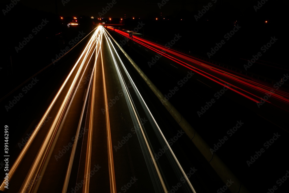 highway traffic at night with little traffic and city lights in the background highway traffic at night with little traffic and city lights in the background