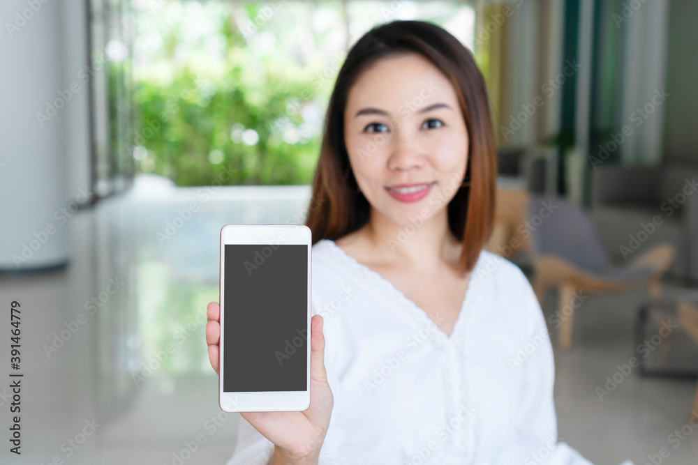 Fototapeta premium Beautiful young Asian girl holding mobile phone for copy space. Technology and lifestyle concept. closeup