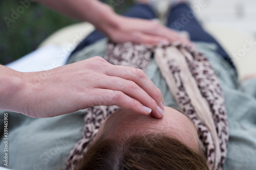 Woman on a couch and a therapist touching her head and stomach photo