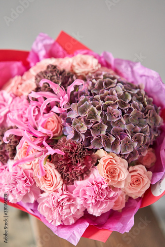 Pink and purple flowers. Autumn bouquet of mixed flowers in glass vase on wooden table. The work of the florist at a flower shop. Fresh cut flower. photo