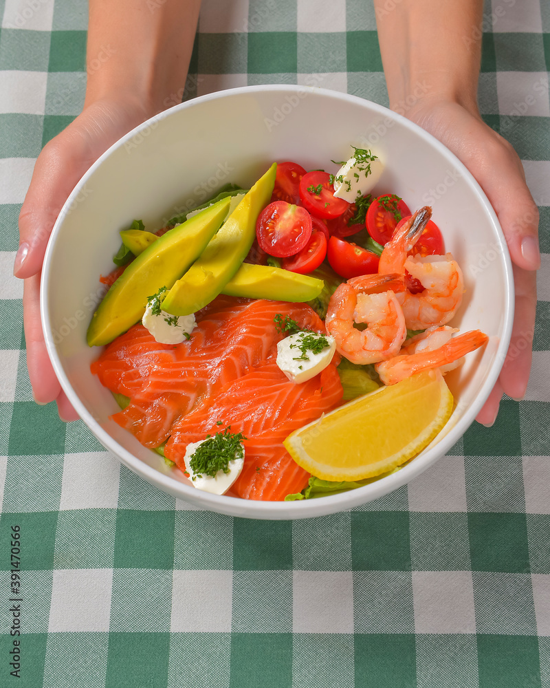 Fresh salad with seafoods, tomato and herbs. Red salmon, small shrimps, avocado, cherry tomatoes. Fresh salad with seafoods, tomato and herbs. Red salmon, small shrimps, avocado, cherry tomatoes.