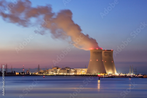 Riverbank with nuclear power plant Doel during a colorful sunset, Port of Antwerp, Belgium