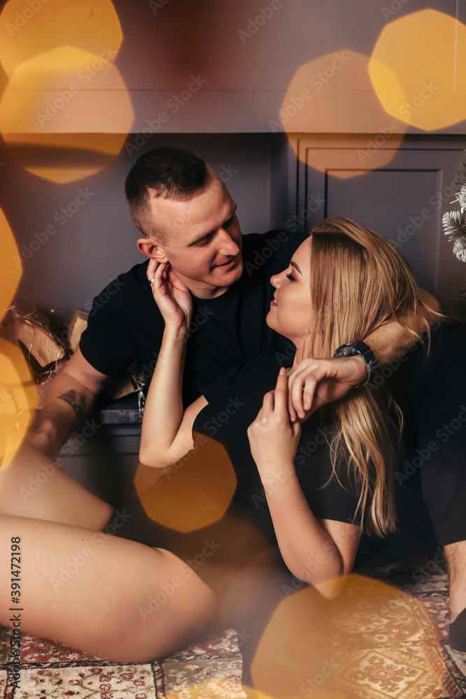 Passionate romantic couple spend time together before the New Year near a beautiful Christmas tree at home. Sexy young woman and handsome man hugging and celebrating new year Passionate romantic couple spend time together before the New Year near a beautiful Christmas tree at home. Sexy young woman and handsome man hugging and celebrating new year