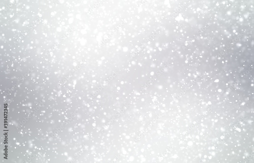 Soft fluffy snow flakes fall on light gray background. Blurred texture. Winter empty background.
