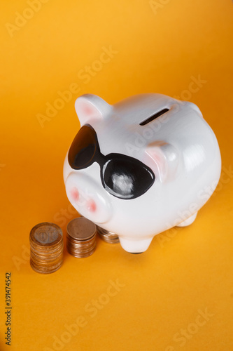  financial savings for a good life. piggy bank and coins yellow background