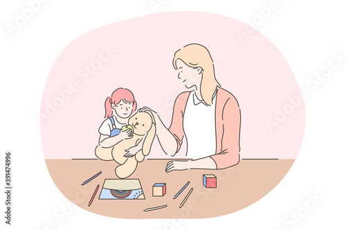 Happy leisure and activities at home with children concept. Young woman mother cartoon character playing, drawing and feeding toy together with her small daughter at home. Relax, rest, family