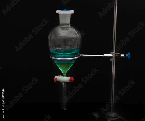 The study Separating by filtration the component substances from liquid mixture in Lab. Separating natural product use dichloromethane with water have two layer blue and yellow in separating funnel photo