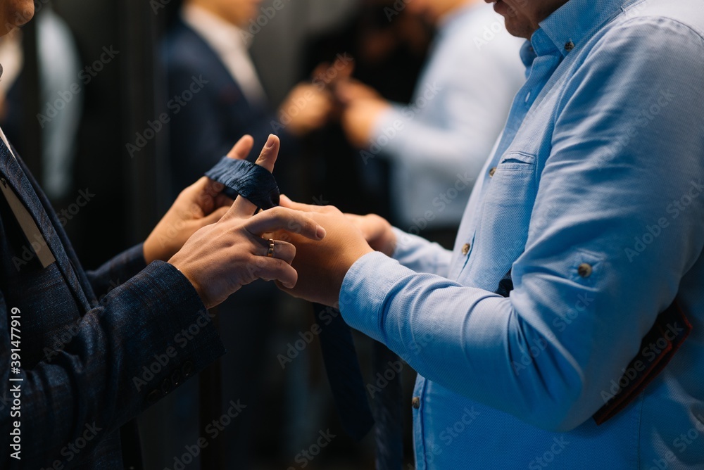 Portrait of businessman adjusting his necktie standing in office Portrait of businessman adjusting his necktie standing in office