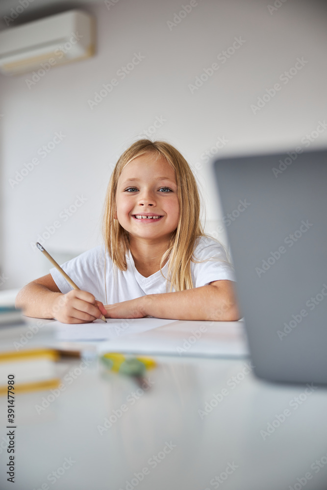 Cute small miss holding pencil in hand while spending time at the exercises books Cute small miss holding pencil in hand while spending time at the exercises books