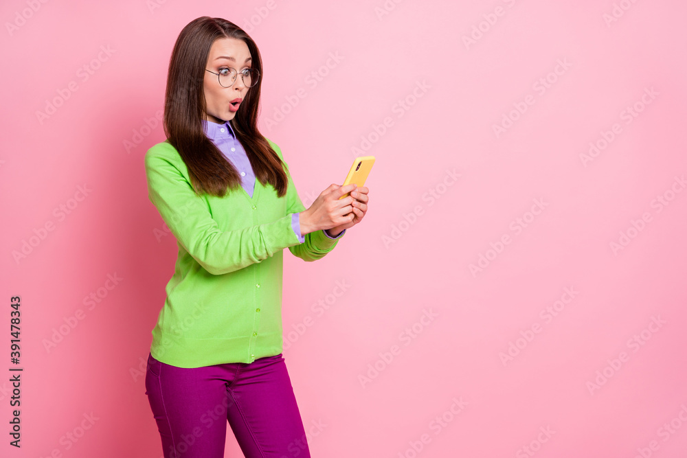 Photo of astonished girl use smartphone wear purple good look clothes isolated over pink color background Photo of astonished girl use smartphone wear purple good look clothes isolated over pink color background