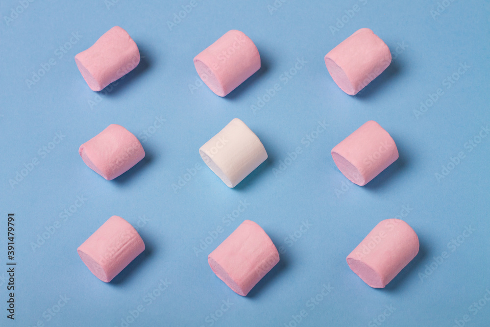 Obraz premium Colorful marshmallow on blue background. Pink and white marshmallow top view.