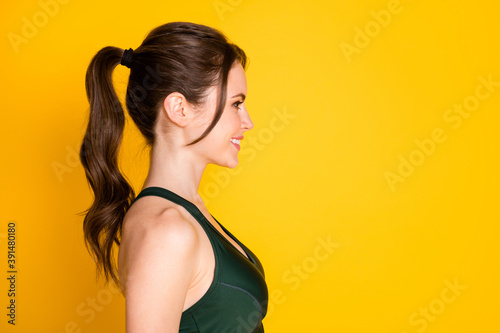 Close-up profile side view portrait of attractive sportive cheerful girl fitness isolated over bright yellow color background