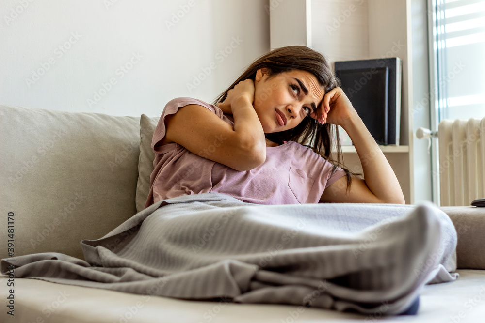 Young woman experiencing neck pain at home. Photo of woman sitting in bed and suffering from neck ache at home. Cropped shot of an attractive young girl suffering from neck ache while sitting at home. Young woman experiencing neck pain at home. Photo of woman sitting in bed and suffering from neck ache at home. Cropped shot of an attractive young girl suffering from neck ache while sitting at home.