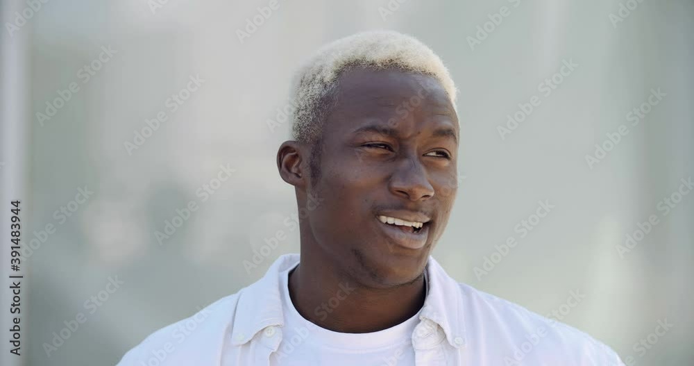 Portrait of emotional young african guy doubting feels sadness stress thoughtfully shrugs shoulders sighs suffers from uncertainty stands alone outdoors in new unfamiliar city problem trouble concept