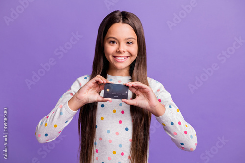 Konstfotografi Photo portrait of cheerful schoolgirl showing plastic bank credit card isolated
