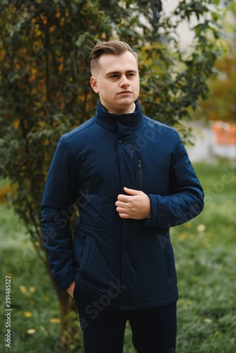 Fototapeta Naklejka Na Ścianę i Meble -  Portrait of a stylish man with a beard dressed in a coat, outdoors