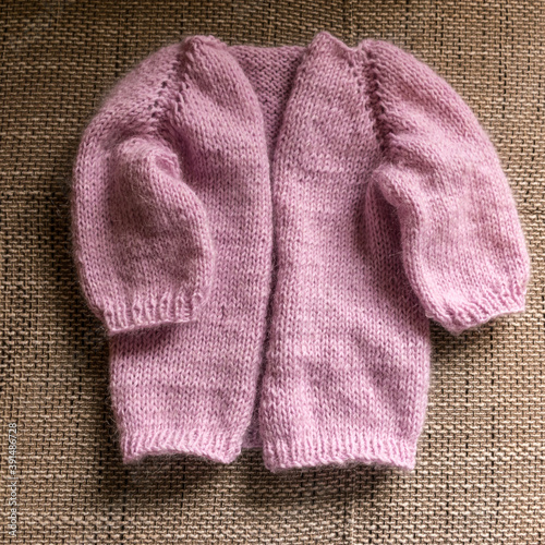 knitted jacket for a girl, pink color, knitting texture, handicraft concept, hand knitting, autumn