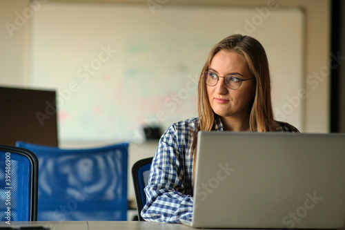 The programmer girl works at the computer	Girls in science. In an empty office during a pandemic.