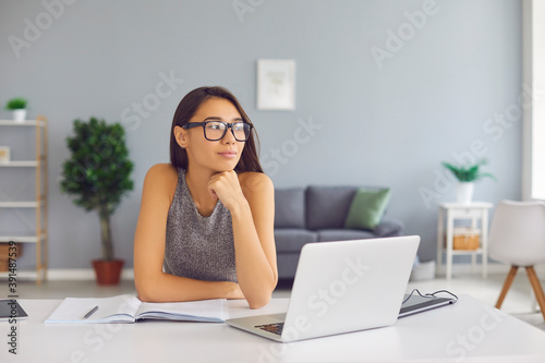 Creative student, writer or business course author sitting at desk with laptop and thinking