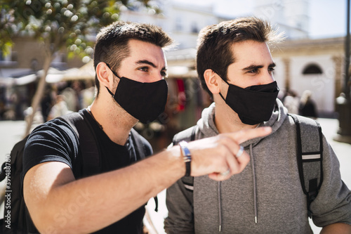 Closeup focus shot of young men wearing facemask on a sunny day photo