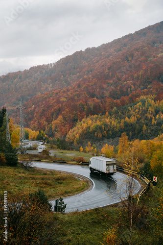Fototapeta Naklejka Na Ścianę i Meble -  autumn road with truck in the mountains