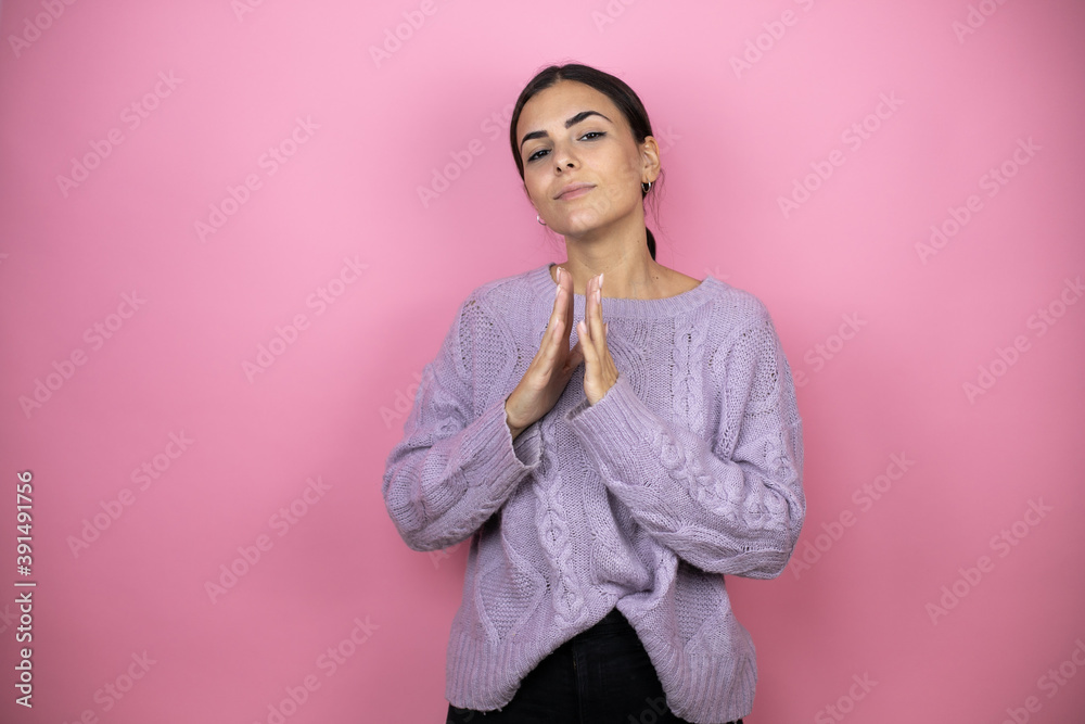 Beautiful woman wearing a casual violet sweater over pink background with Hands together and fingers crossed smiling relaxed and cheerful. Success and optimistic Beautiful woman wearing a casual violet sweater over pink background with Hands together and fingers crossed smiling relaxed and cheerful. Success and optimistic