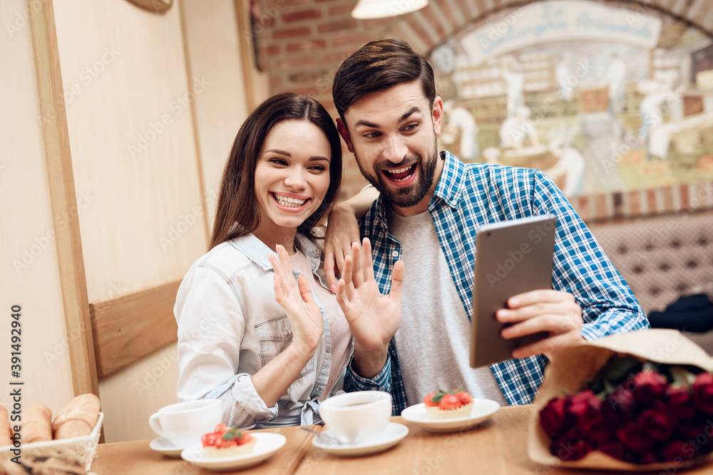 Young Couple Using Tablet in Modern Cafeteria. Young Couple Using Tablet in Modern Cafeteria.