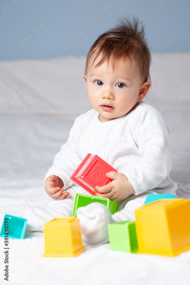 Baby playing with color cubes on bed Baby playing with color cubes on bed
