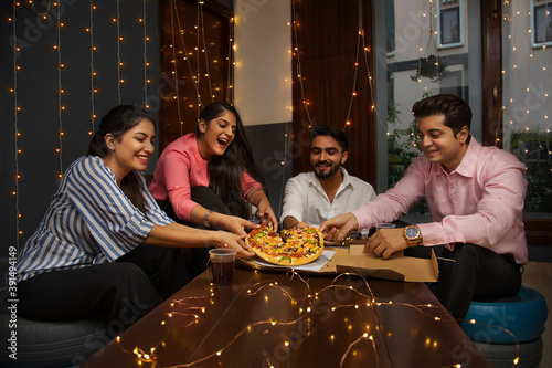 A GROUP OF HAPPY COLLEGUES SHARING A PIZZA	 photo