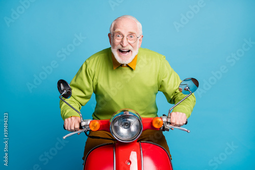 Photo of pensioner carefree grandpa ride motorcycle crazy expression wear eyeglasses green sweater isolated blue color background © deagreez