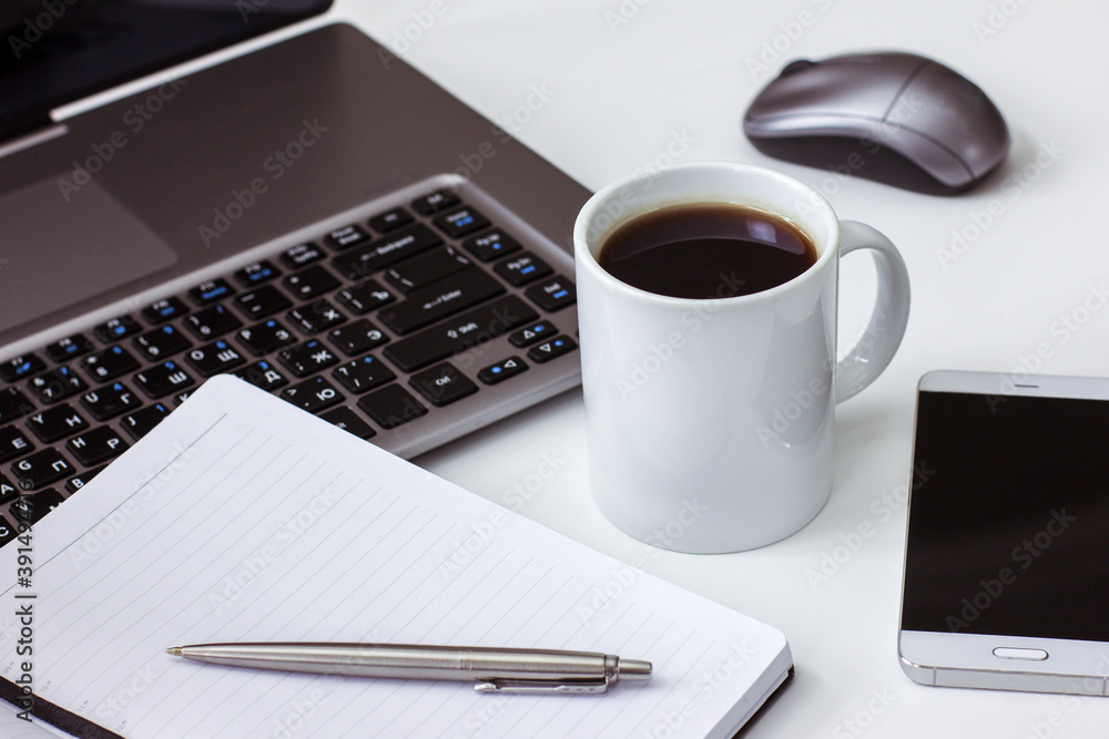 Desktop at home laptop open Notepad with pen coffee Cup on white table Desktop at home laptop open Notepad with pen coffee Cup on white table