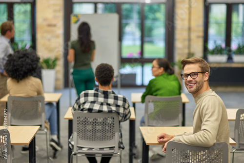 Cheerful caucasian man smiling at camera during business seminar or training